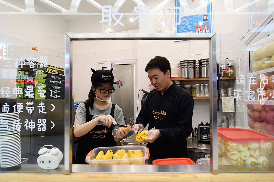 Cui Jianwei trabaja con un empleado en una tienda de Taiyuan, en la provincia de Shanxi, el 26 de abril de 2016. Para crear buenos sabores, todos los ingredientes en los helados son frescos, dijo Cui. [Foto/Xinhua]