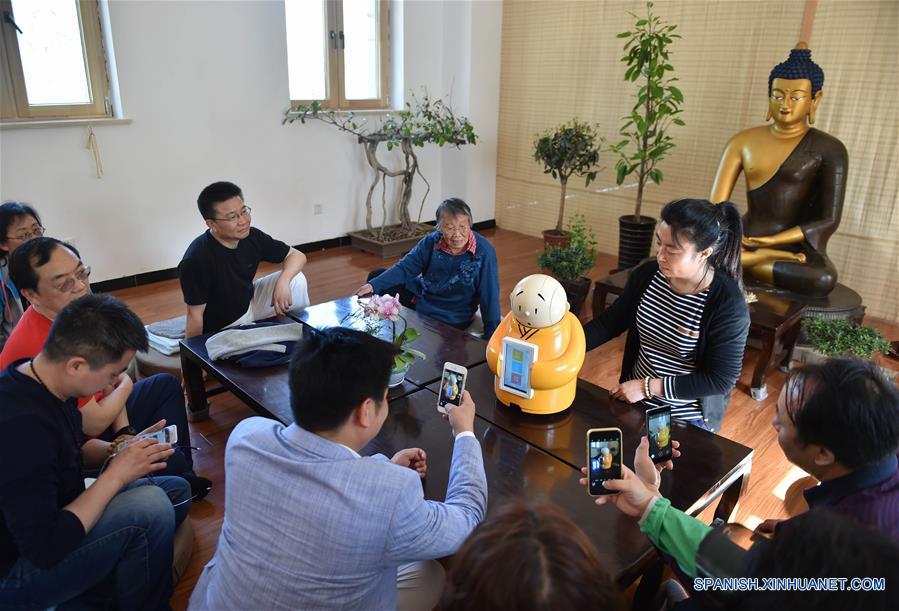 BEIJING, mayo 8, 2016 (Xinhua) -- Imagen del 22 de abril de 2016 muestra que los visitantes conversaban con el Monje Xian'er, un personaje de caricaturas del Monasterio Longquan, en el monasterio en Beijing, capital de China. El Monje Xian'er es un popular personaje de caricaturas creado por el maestro Xianfan para responder acertijos introspectivos de los visitantes y traerles la paz. El Monasterio Longquan está localizado al pie de la Montaña Fenghuangling (Phoenix Ridge), en las afueras occidentales de Beijing. Primero construido en la Dinastía Liao 907-1125), el monasterio recupera la reputación al acoger la era del internet móvil. (Xinhua/Luo Xiaoguang) 