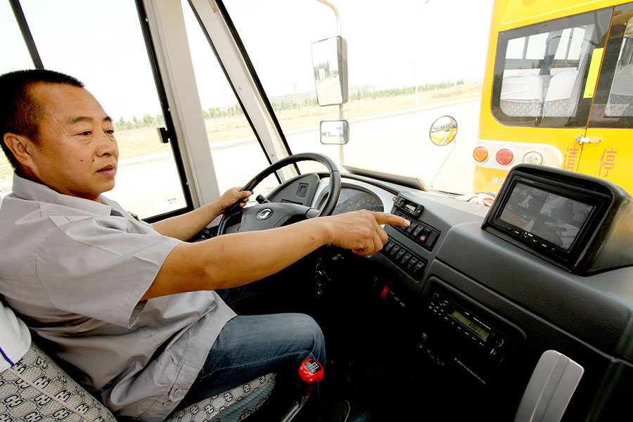 Un conductor muestra el sistema de control del autobús escolar. 