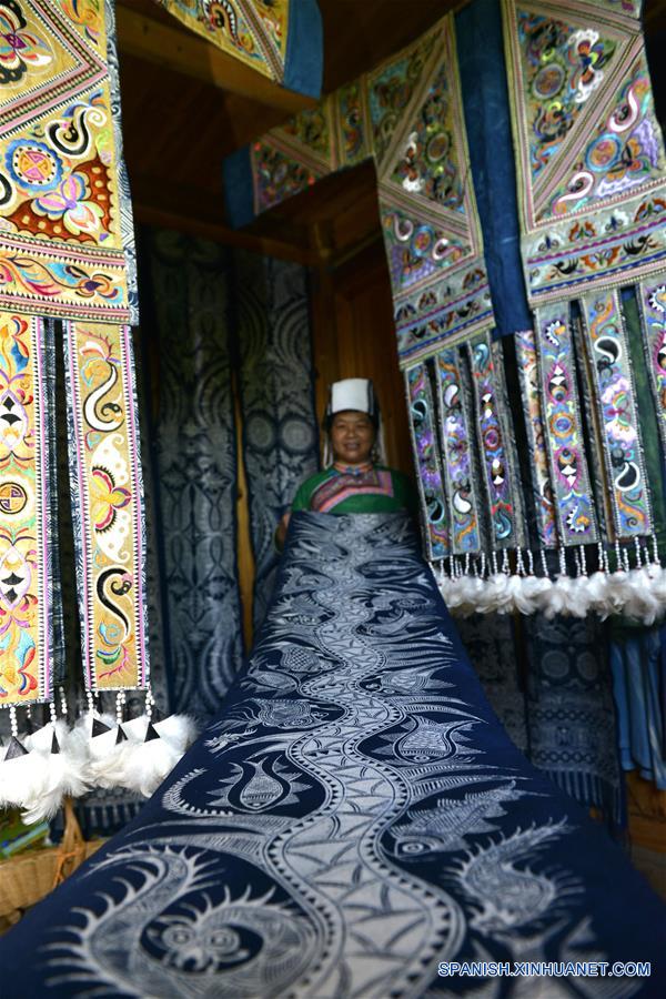 GUIZHOU, mayo 17, 2016 (Xinhua) -- Yuan Renzhi muestra un batik elaborado por ella, en la villa Wuji, en el municipio de Tashi, del condado de Rongjiang, en la provincia de Guizhou, en el suroeste de China, el 16 de mayo de 2016. Las mujeres del grupo étnico miao que viven en la villa Wuji, ubicada en las remotas colinas del suroeste de China, maestras en sus bordados y batiks étnicos, que han sido enlistados por el gobierno de China como patrimonio cultural intangible. El gobierno local ha prestado mucha atención a la herencia de las habilidades tradicionales, promoviendo el sentido de protección y desarollo de mercados de los residentes. (Xinhua/Wang Bingzhen)