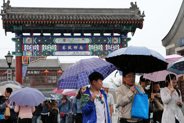 La gente visita Nanluoguxiang, un callejón popular llena de elementos tradicionales chinos en Beijing. [Foto de Wang Zhuangfei]