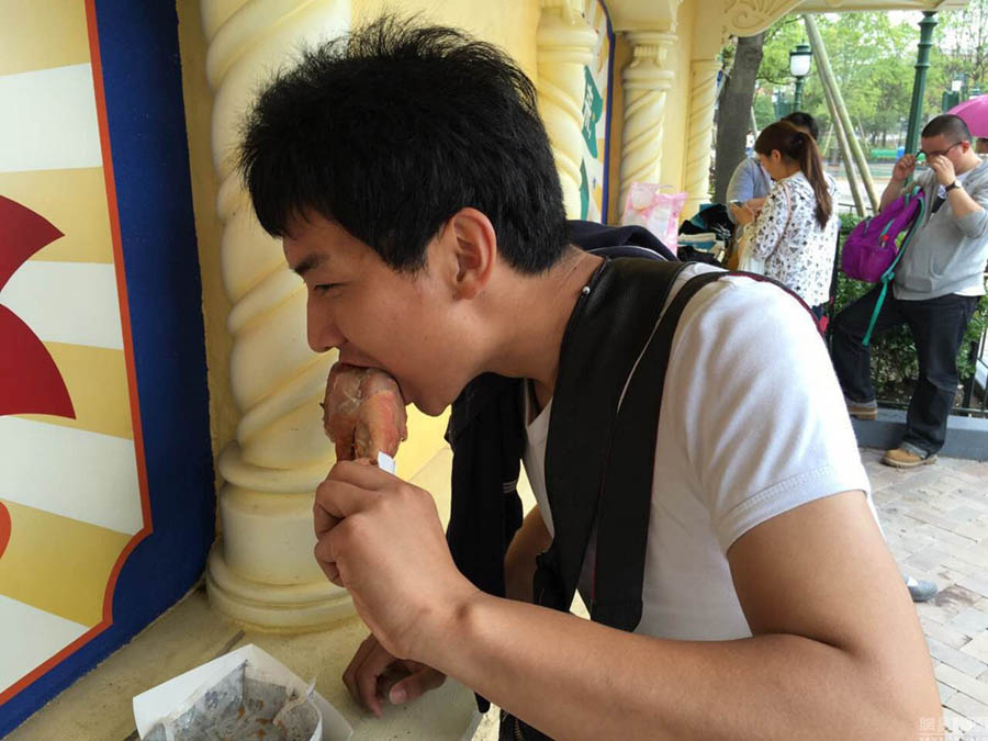Foto del 20 de mayo de 2016 muestra a un visitante comiendo muslo de pavo en Disneyland Shanghai. [Foto: CRIONLINE.com]