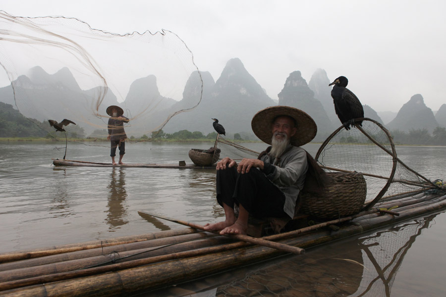 Los hermanos ancianos posan sobre sus balsas de bambú en el río Lijiang en la ciudad de Guilin, región autónoma Zhuang de Guangxi. [Fotografía de Huo Yan/chinadaily.com.cn]