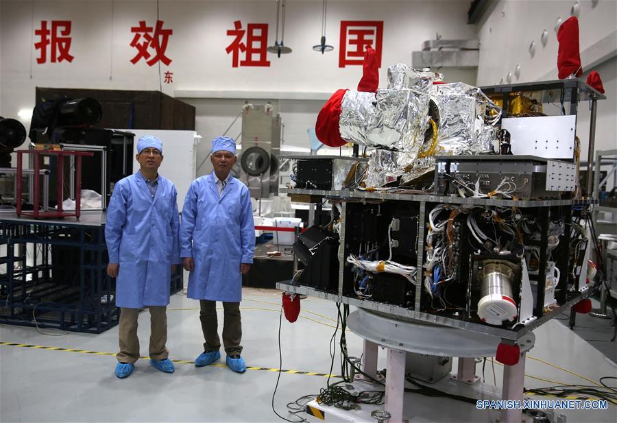 Imagen del 25 de mayo de 2016 del ingeniero general Zhu Zhencai (i), y el ingeniero subjefe Zhou Yilin (d), posando con el satélite cuántico en el Centro de Ingeniería para Microsatélites de Shanghai de la Academia de Ciencias de China, en Shanghai, en el este de China. China planea lanzar el primer satélite cuántico del mundo que puede conseguir comunicación segura en julio. El satélite está dedicado a experimentos de ciencia cuántica. (Xinhua/Cai Yang)