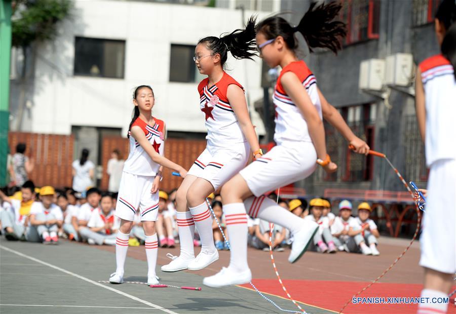 Niños brincan la cuerda durante una celebración para recibir el próximo Día del Niño, en la Escuela Primaria Fuxue Hutong, en Beijing, capital de China, el 30 de mayo de 2016. (Xinhua/Luo Xiaoguang)