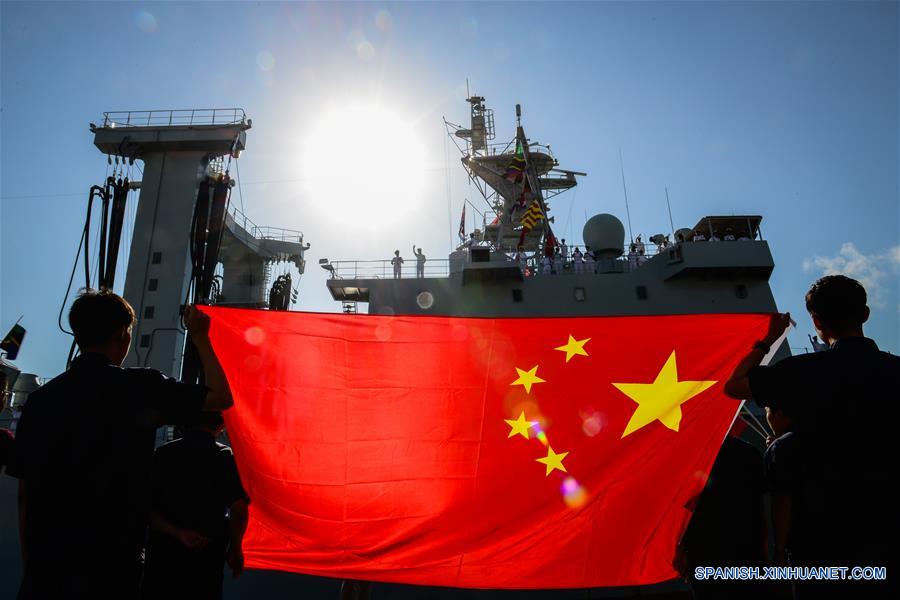  DAR ES SALAAM, mayo 30, 2016 (Xinhua) -- Residentes chinos en Tanzania sostienen una bandera nacional de China para recibir al barco de abastecimiento "Taihu" de la armada china, en Dar es Salaam, Tanzania, el 30 de mayo de 2016. Tres buques de la armada china atracaron el lunes en el puerto de Dar es Salaam, Tanzania, para realizar una visita de cuatro días cuyo fin es compartir experiencias con sus homólogos tanzanos sobre la forma de frenar la piratería en el océano Indico. (Xinhua/Zhai Jianlan)