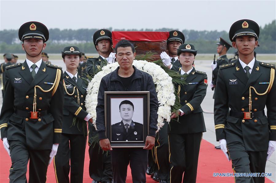 Shen Mingming (c), hermano mayor del soldado chino de las fuerzas de paz de la Organización de las Naciones Unidas (ONU), Shen Liangliang, escolta el féretro de Shen Liangliang a la carroza en el Aeropuerto Longjia en Changchun, capital de la provincia de Jilin, en el noreste de China, el 9 de junio de 2016. El cuerpo del soldado chino de las fuerzas de paz de la Organización de las Naciones Unidas (ONU) Shen Liangliang, quien murió en un ataque terrorista en Mali el mes pasado, arribó la tarde del jueves a la ciudad de Changchun, en el noreste de China. (Xinhua/Yin Gang)