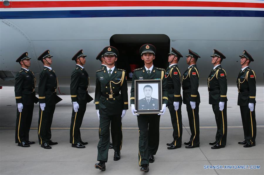 Guardias de honor se preparan para escoltar el féretro del soldado chino de las fuerzas de paz de la Organización de las Naciones Unidas (ONU), Shen Liangliang, fuera del avión en el Aeropuerto Longjia en Changchun, capital de la provincia de Jilin, en el noreste de China, el 9 de junio de 2016. El cuerpo del soldado chino de las fuerzas de paz de la Organización de las Naciones Unidas (ONU) Shen Liangliang, quien murió en un ataque terrorista en Mali el mes pasado, arribó la tarde del jueves a la ciudad de Changchun, en el noreste de China. (Xinhua/Yin Gang)
