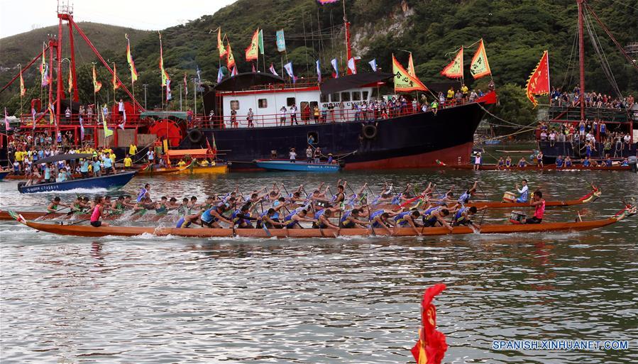 Personas observan una carrera del bote de dragón, en Tai O, Hong Kong, en el sur de China, el 9 de junio de 2016. Tai O celebró el jueves la carrera del bote del dragón anual o Festival Duanwu. (Xinhua/Li Peng)