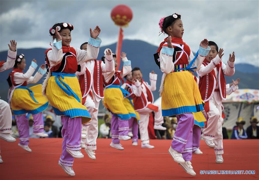 Estudiantes locales bailan durante un festival de carreras de caballos en Shangri-la, Prefectura Autónoma Tibetana de Diqing, en la provincia de Yunnan, en el suroeste de China, el 9 de junio de 2016. Un total de 194 caballos participarán en el festival étnico tradicional de tres días de duración, que dio inicio el jueves. (Xinhua/Zhou Lei)  