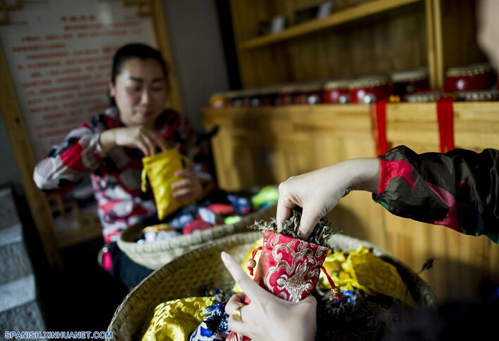 Personas elaboran bolsas con hierbas perfumadas, para marcar el próximo Festival del Bote del Dragón, en el condado Zigui, capital de la provincia central de Hubei, China, el 8 de junio de 2016. El Festival del Bote de Dragón o "Duanwu" en chino, se celebra el quinto día del quinto mes del calendario lunar, celebrándose este año el 9 de junio. (Xinhua/Xiao Yijiu)  
