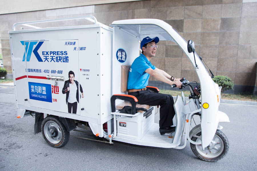 Chen Xiangyang, vicepresidente ejecutivo de TK Express, conduce un triciclo de mensajería para entregar paquetes a los clientes en persona durante la Cumbre Mundial de Logística Inteligente 2016 en Hangzhou, capital de la provincia de Zhejiang, el 13 de junio de 2016. [Foto/VCG]