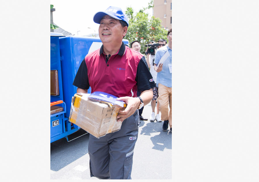 Yu Weijiao, presidente ejecutivo de YTO Express, en camino para entregar un paquete a un cliente durante la Cumbre Mundial de Logística Inteligente 2016 Global en Hangzhou, capital de la provincia de Zhejiang, el 13 de junio de 2016. [Foto/VCG]