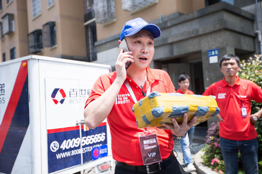 Zhou Jian, director general de Best Logistics, llama a un cliente antes de entregarle su paquete durante la Cumbre Mundial de Logística Inteligente 2016 Global en Hangzhou, capital de la provincia de Zhejiang, el 13 de junio de 2016. [Foto/VCG]