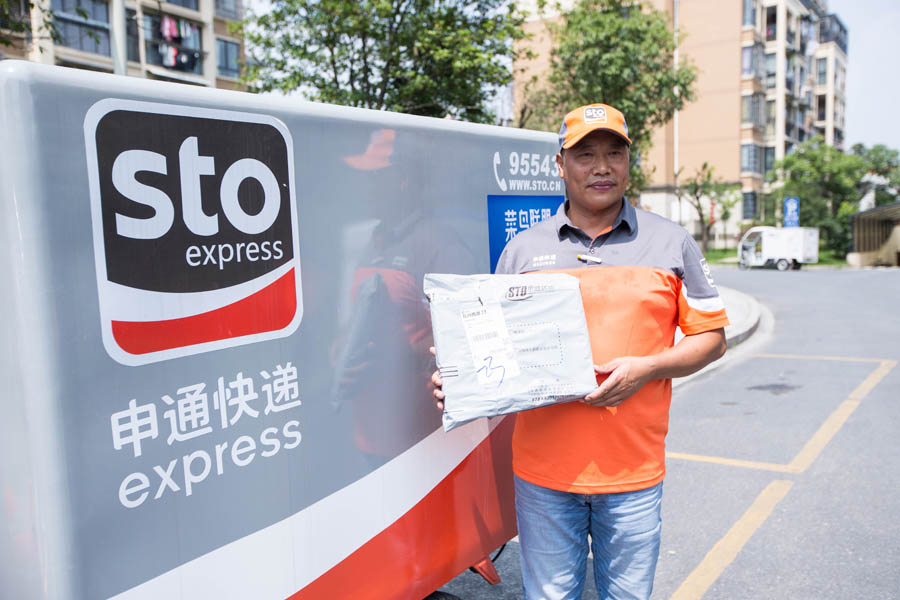 Chen Dejun, presidente ejecutivo de STO Express, muestra un paquete antes de entregarlo a un cliente durante la Cumbre Mundial de Logística Inteligente 2016 Global en Hangzhou, capital de la provincia de Zhejiang, el 13 de junio de 2016. [Foto/VCG]