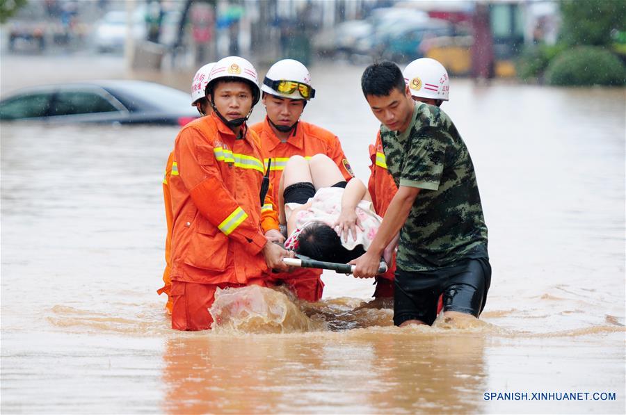 Rescatistas evacúan a una mujer atrapada en un camino inundado en Jiujiang, provincia de Jiangxi, en el este de China, el 15 de junio de 2016. Una lluvia torrencial afectó el miércoles la ciudad. (Xinhua/Hu Guolin)