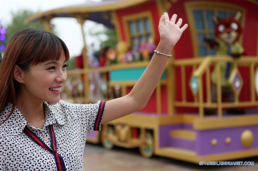 Una visitante interactúa con los actores que participan en un desfile en Shanghai Disneyland, en Shanghai, en el este de China, el 15 de junio de 2016. El complejo turistico Shanghai Disney Resort abrirá oficialmente el 16 de junio. (Xinhua/Ding Ting)