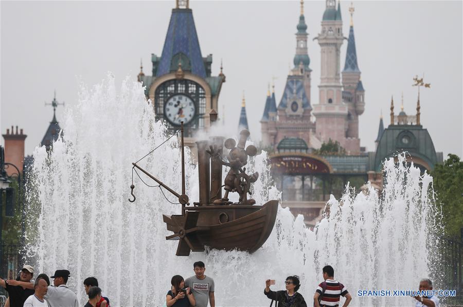 Turistas y ciudadanos posan a la entrada de Shanghai Disneyland, en Shanghai, en el este de China, el 15 de junio de 2016. El complejo turistico Shanghai Disney Resort abrirá oficialmente el 16 de junio. (Xinhua/Pei Xin)