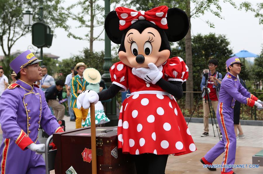 Una empleada imitando al personaje Minnie del clásico de dibujos animados de Disney, participa en un desfile en Shanghai Disneyland, en Shanghai, en el este de China, el 15 de junio de 2016. El complejo turistico Shanghai Disney Resort abrirá oficialmente el 16 de junio. (Xinhua/Ding Ting)