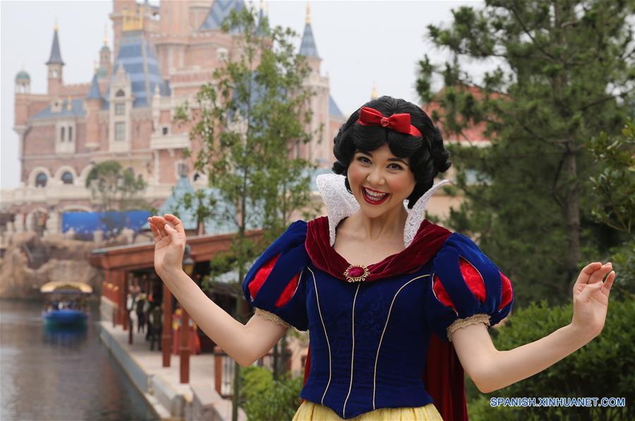 Una empleada imitando al personaje Blancanieves del clásico de dibujos animados de Disney, saluda a los turistas en Shanghai Disneyland, en Shanghai, en el este de China, el 15 de junio de 2016. El complejo turistico Shanghai Disney Resort abrirá oficialmente el 16 de junio. (Xinhua/Pei Xin)