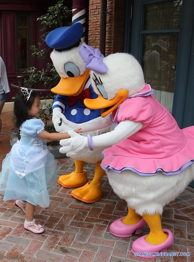 Una niña estrecha la mano con el Pato Donald y Daisy en el recién inaugurado Complejo Turístico Shanghai Disney Resort, en Shanghai, en el este de China, el 16 de junio de 2016. Shanghai Disney Resort, con una combinación única de la magia de Disney y la cultura china, abrió sus puertas oficialmente el jueves. (Xinhua/Pei Xin)