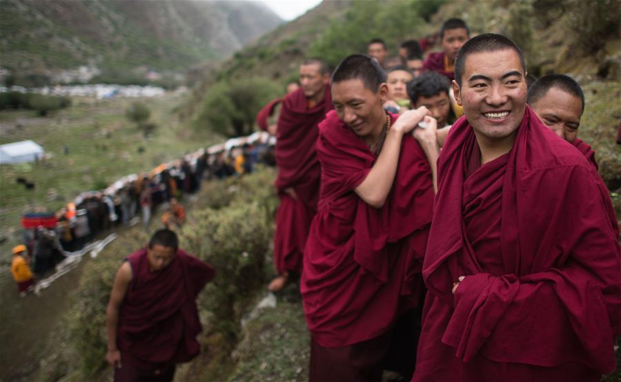LHASA, junio 16, 2016 (Xinhua) -- Seguidores del budismo asisten a una actividad de adoración de Thangka, en el Monasterio Tsurphu en Lhasa, capital de la región autónoma del Tíbet, en el suroeste de China, el 16 de junio de 2016. Una actividad anual de adoración Thangka para mostrar un Thangka de 38 por 35 metros fue llevada a cabo el jueves en el Templo Tsurphu, una base importante de la escuela Kagyu en el budismo tibetano. La Thangka es una bandera budista tibetana de seda pintada o bordada. (Xinhua/Purbu Zhaxi)