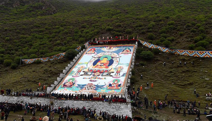Seguidores del budismo asisten a una actividad de adoración de Thangka, en el Monasterio Tsurphu en Lhasa, capital de la región autónoma del Tíbet, en el suroeste de China, el 16 de junio de 2016. Una actividad anual de adoración Thangka para mostrar un Thangka de 38 por 35 metros fue llevada a cabo el jueves en el Templo Tsurphu, una base importante de la escuela Kagyu en el budismo tibetano. La Thangka es una bandera budista tibetana de seda pintada o bordada. (Xinhua/Chogo)