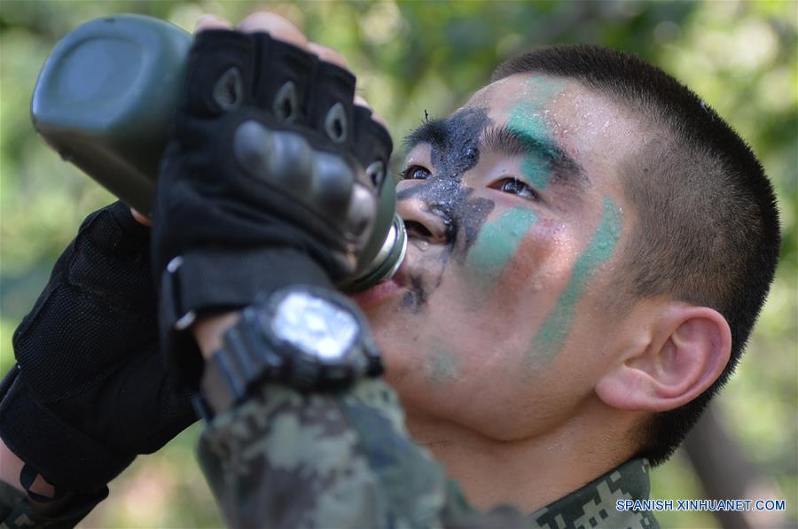 Un soldado de la Fuerza de Policía Armada del Pueblo Chino bebe agua durante una sesión de entrenamianto en el Monte Tai en Taian, provincia de Shandong, en el este de China, el 16 de junio de 2016. Soldados de la Fuerza de la Policía Armada en Shandong llevaron a cabo el jueves sesiones de entrenamiento en el Monte Tai. El entrenamiento durará 7 días y noches, incluyendo 43 sesiones de 6 categorías. (Xinhua/Zhu Zheng)