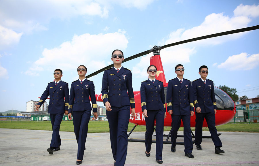 Pilotos de helicóptero posan para el anuncio de inscripción de una escuela de aviación civil de Chengdu, provincia de Sichuan, el 7 de junio de 2016.