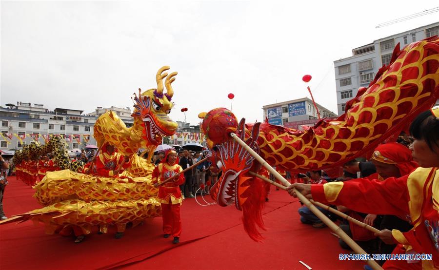 Personas realizan una danza de león durante el festival fenlong, en el condado de Huanjiang, en la Región Autónoma Zhuang de Guangxi, en el sur de China, el 18 de junio de 2016. El evento contará con actividades de baile, festival de comida, concursos de bote dragón, y actividades de canto. Los aldeanos del grupo étnico Maonan, festejan su festival anual para orar por la cosecha. (Xinhua/Huang Shangbiao)