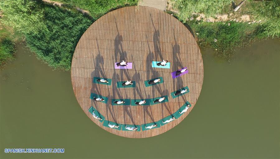 Henan: Personas practican yoga en el Parque Lago Longquan en Jiaozuo