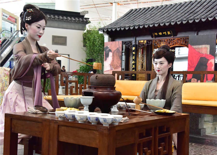Dos actrices en traje clásico realizan la ceremonia del té durante el espectáculo de arte digital Night Revels of Han Xizai del Aeropuerto Internacional de Beijing, el 21 de junio de 2016.
