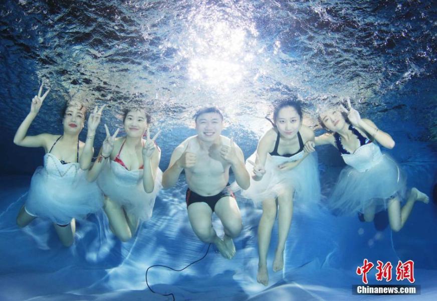 Los estudiantes posan bajo el agua para foto de la graduación