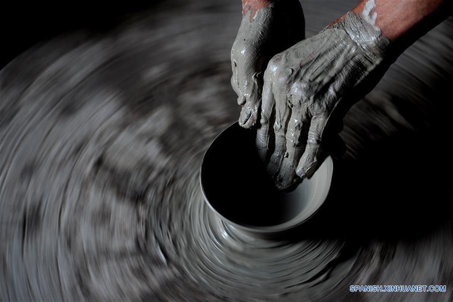 Imagen del 28 de junio de 2016 de un artesano elaborando un producto de porcelana, en la zona turística de Yaotou Kiln en el municipio de Yaotou del condado de Chengcheng, provincia de Shaanxi, en el noroeste de China. El sitio de antiguos hornos populares, cubriendo un área de cuatro kilómetros cuadrados, tiene una historia de elaboración de productos de cerámica de más de mil años. La técnica de elaboración de cerámica en Yaotou Kiln fue incluida en el Patrimonio Nacional Cultural Intangible en el 2006. (Xinhua/Tao Ming)