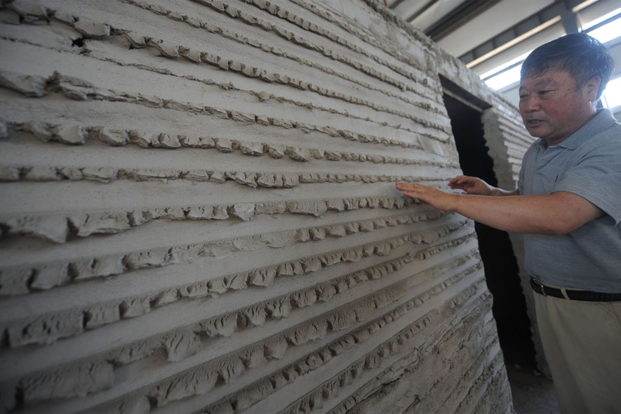 Un hombre toca un muro en el interior de la primera casa construida con impresión 3D en el distrito Tongzhou de Beijing, el 1 de julio de 2016. 