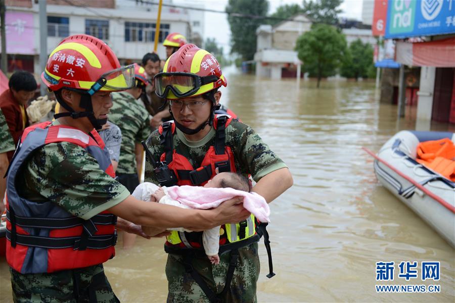 La foto muestra a soldados trasladando a un bebé rescatado en la inundación. (Xinhua)
