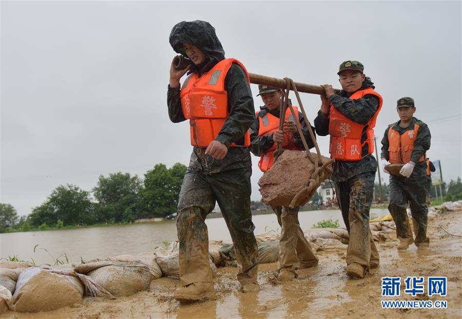 Policias armadas en la provincia china de Anhui cargaron piedras para reforzar un dique el 5 de julio. (Xinhu/Xu Wei)