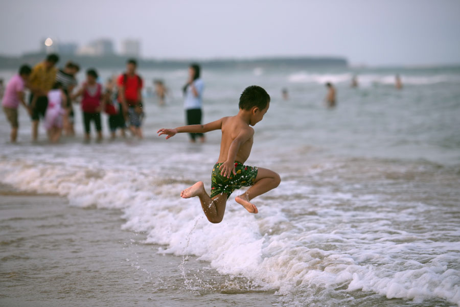 Un niño salta al mar en Qionghai de Hainan, el 10 de julio de 2016. [Foto/VCG]