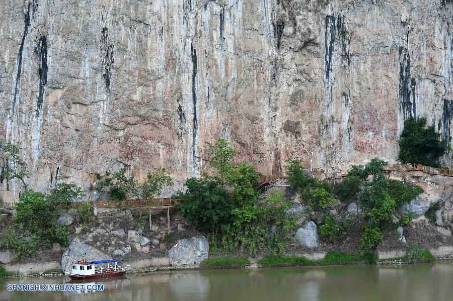 GUANGXI, julio 15, 2016 (Xinhua) -- Vista de las pinturas rupestres sobre la Montaña Huashan por el río Zuojiang en el condado de Ningming, en la Región Autónoma Zhuang de Guangxi, en el sur de China, el 15 de julio de 2016. El Paisaje Cultural de Arte Rupestre de Zuojiang de Guangxi fue añadido este viernes a la lista del Patrimonio Mundial en la 40 sesión del Comité del Patrimonio Mundial llevada a cabo en Estambul. Las pinturas rupestres que se componen de más de 1,900 dibujos que representan los tambores y elementos relacionados con registros simbólicos asociados directamente con la cultura del tambor de bronce del pueblo Luoyue alguna vez generalizadas en la región hace más de 2,000 años. (Xinhua/Zhou Hua)