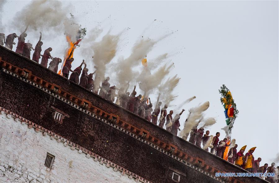 Monjes lanzan tsampa, un alimento horneado hecho de harina de cebada, durante el evento del descubrimiento del Buda en el monasterio Zhaxi Lhunbo, en Xigaze, en la región autónoma del Tíbet, en el suroeste de China, el 20 de julio de 2016. La ceremonia anual concluyó el miércoles. (Xinhua/Purbu Zhaxi)