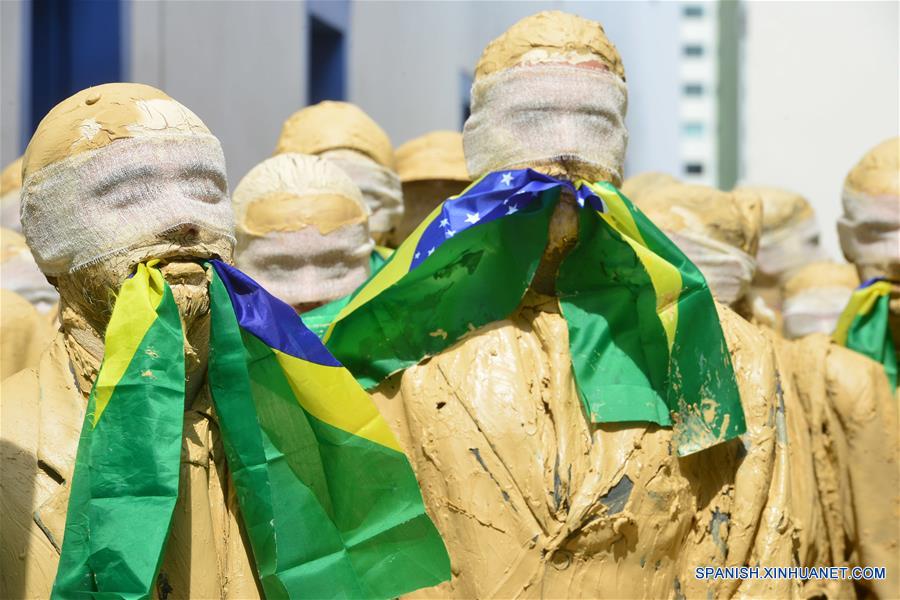 Actores cubiertos de lodo participan durante una manifestación silenciosa en favor de la democracia en la ciudad de Sao José dos Campos, estado de Sao Paulo, Brasil, el 3 de septiembre de 2016. De acuerdo con información de la prensa local, un grupo de actores de teatro procedentes del 31 Festival de Teatro protagonizaron la manifestación.