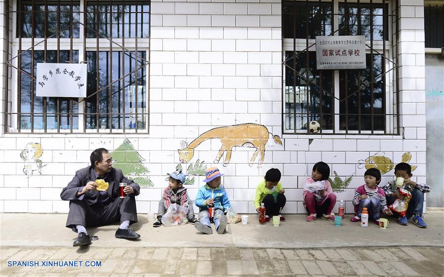 Imagen del 8 de septiembre de 2016 del maestro Hua Fulin (i), de 56 años de edad, el único profesor de la pequeña escuela de la villa de Kunlun, tomando su almuerzo con sus alumnos, en la villa de Kunlun de la ciudad de Haidong, provincia de Qinghai, en el noroeste de China. A unos 50 kilómetros de distancia del condado más cercano, la pequeña escuela de Kunlun ahora tiene sólo ocho alumnos y un maestro. (Xinhua/Zhang Hongxiang)