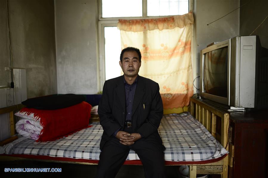 Imagen del 8 de septiembre de 2016 del maestro Hua Fulin, de 56 años de edad, el único profesor de la pequeña escuela de la villa de Kunlun, sentándose en la cama de su dormitorio, en la villa de Kunlun de la ciudad de Haidong, provincia de Qinghai, en el noroeste de China. A unos 50 kilómetros de distancia del condado más cercano, la pequeña escuela de Kunlun ahora tiene sólo ocho alumnos y un maestro. (Xinhua/Zhang Hongxiang)