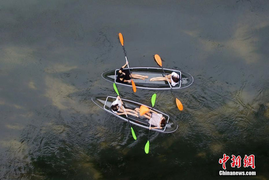 Turistas reman en botes transparentes en Hunan