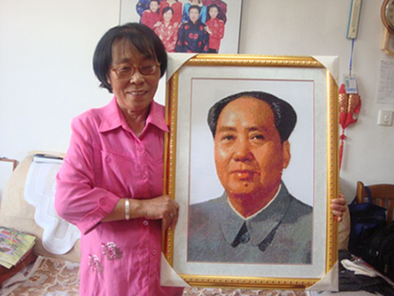 He Hong'e muestra a sus amigos un retrato de Mao Zedong que ella misma bordó en Dongying, provincia de Shandong, Ella pasó medio año bordando este retrato. [Foto: IC]