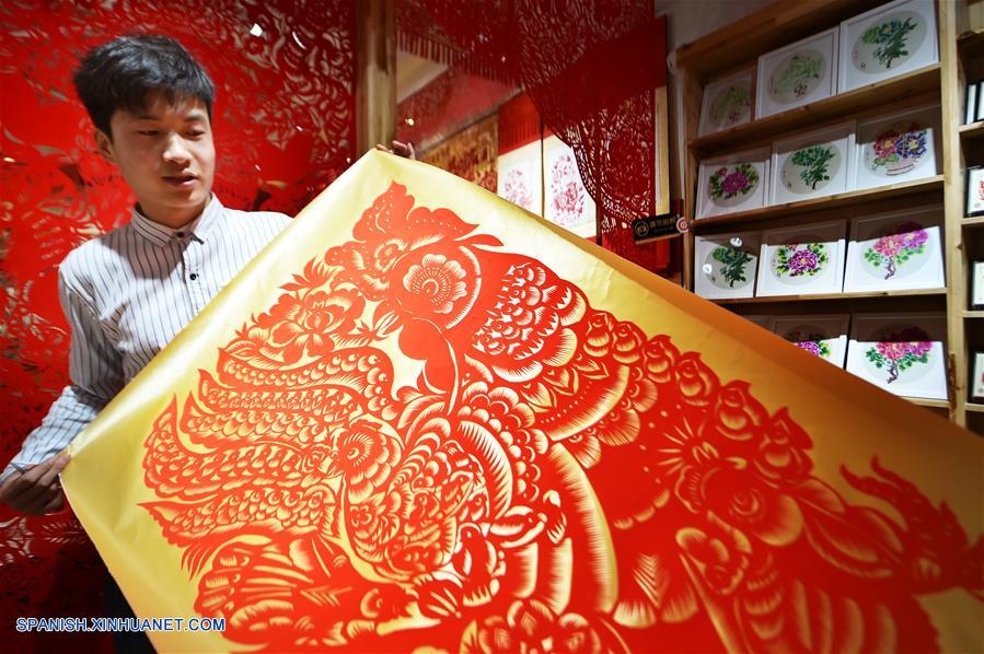 Trabajos de papel cortado de gallos de un joven artista folclórico