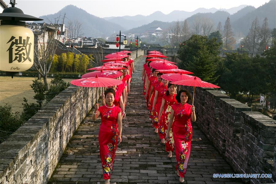 Imagen del 30 de diciembre de 2016 de mujeres portando Qipao, o cheongsam, en un desfile de modas sobre una antigua muralla para saludar el próximo Año Nuevo, en el condado de Xixian, provincia de Anhui, en el este de China. (Xinhua/Wu Sunmin)
