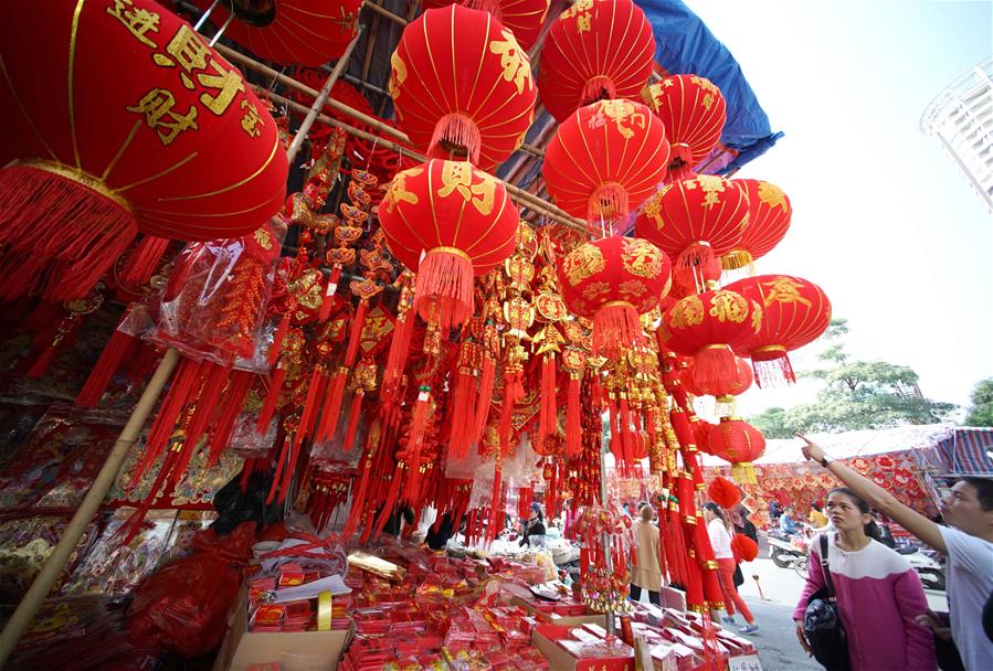Personas seleccionan decoraciones de Año Nuevo en mercado en Nanning