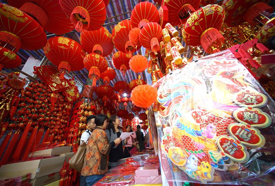 Personas seleccionan decoraciones de Año Nuevo en mercado en Nanning