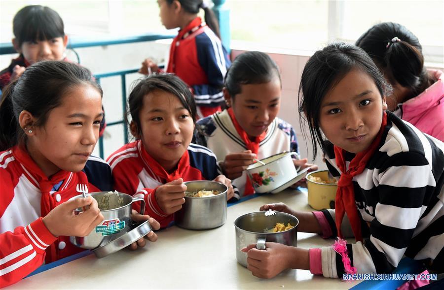 Alumnas de una escuela primaria del poblado Naha del distrito autónomo de la etnia hani de Mojiang de la provincia suroccidental china de Yunnan disfrutan de su almuerzo gratuito. Actualmente, cerca de 27 mil alumnos del distrito comen en escuelas.
